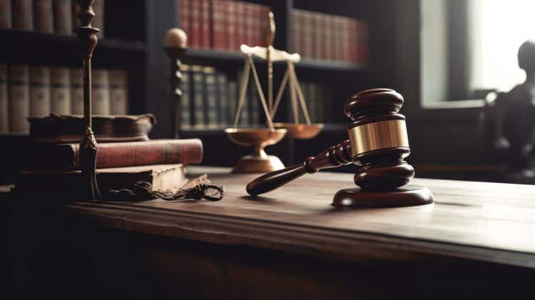 Judge gavel on computer with scales of justice on desk of lawyer