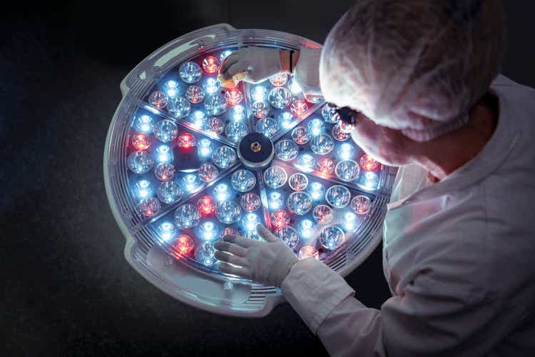 Female engineer preparing operating room lighting in factory clean room