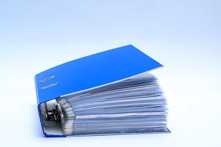 Office binder full of documents on a white background
