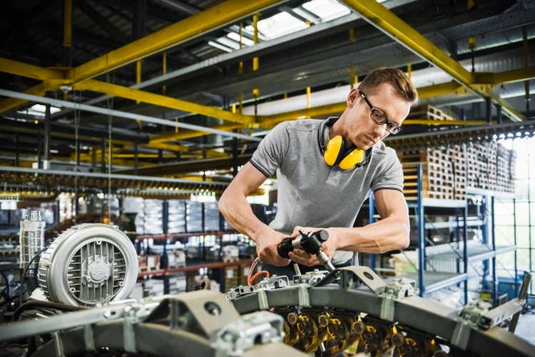 Industrial Worker Repairing A Large Conveyor