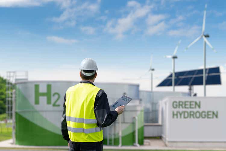 Engineer with tablet computer against the background of a hydrogen factory