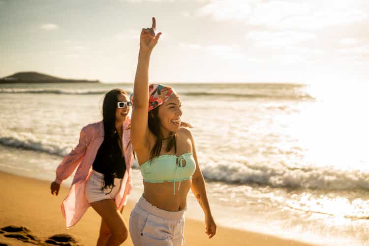 Female friends having fun while walking on the beach