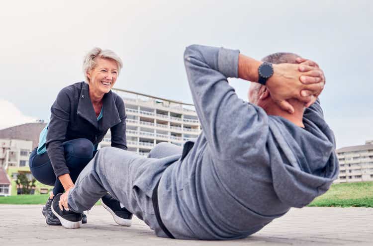 Exercise, health and sit ups with a senior couple training outdoor together for an active lifestyle of training. Workout, fitness or core with a mature man and woman outside on the promenade