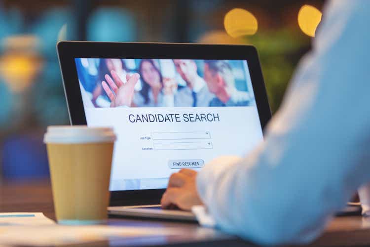 Businessman looking at recruitment website on a laptop computer.