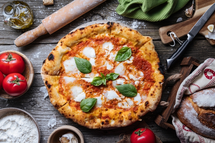 Italian Pizza Napoletana in Messy Kitchen with Cooking Ingredients