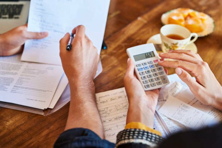 Couple doing paperwork with a calculator at home