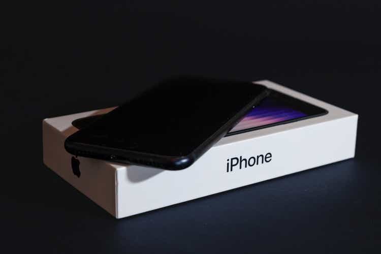 Studio shot of a black Iphone SE3, brand new, with its box package isolated on black background. Released in 2022, IPhone SE 3 is the third generation of Apple.