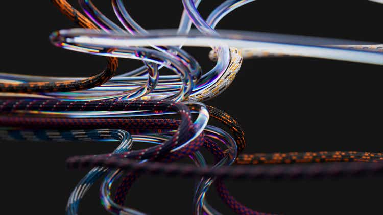 Multi-colored and transparent wires, curved and tangled, create an aesthetic confusion. Black isolated background.