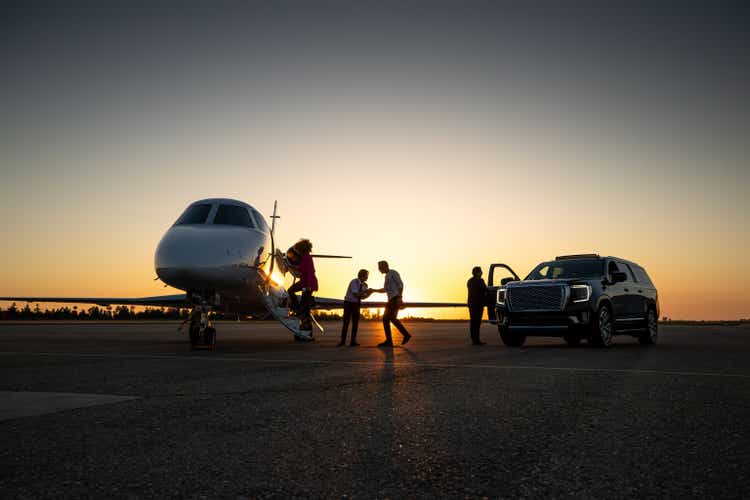 Pilot welcoming passengers to private jet