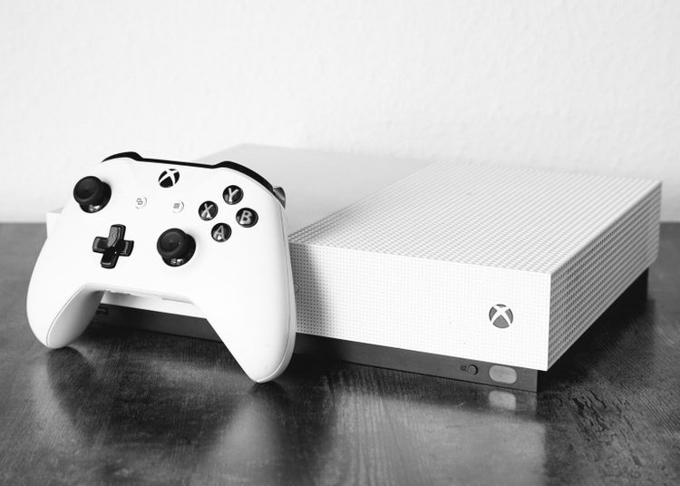 Grayscale shot of an Xbox One S on the table