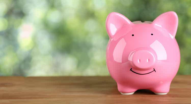 beautiful pink savings pig on top of a wooden board