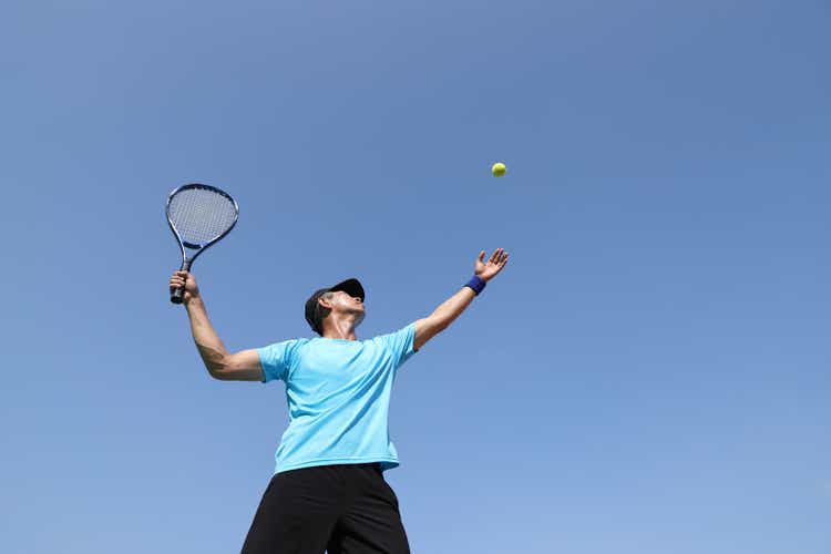 A tennis player serving on a tennis court