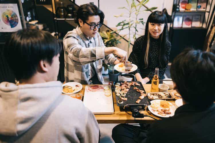 Amigos e colegas, reunindo-se depois do trabalho para um churrasco coreano