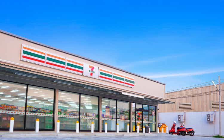 Large 7-11 Convenience Building Store with customer service parking lot area against blue sky background at Samut Sakhon, Thailand - March 31, 2023
