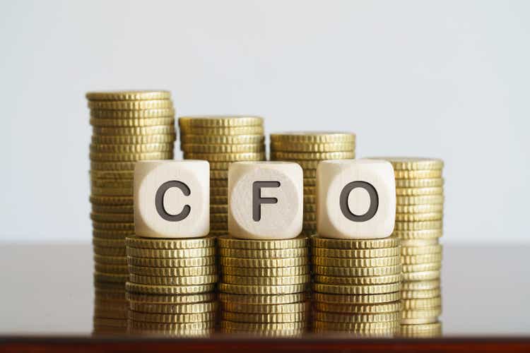 CFO text on wooden cubes standing on coin towers