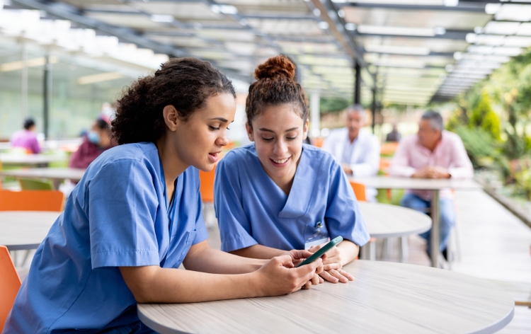 Nurses taking a break and looking at social media at the cafeteria