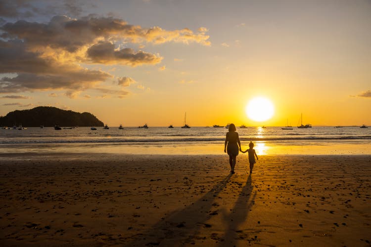 A young girl and her grandmother enjoying sunset at the Pacific Ocean in Costa Rica