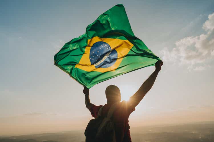 Man holding the flag of Brazil