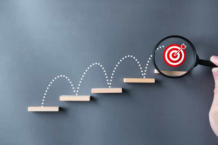 Unlock your business success potential. Stairs, darts, dartboard target, magnifying glass and hand on grey background. Explore growth opportunities and take steps to achieve your ambitions and goals concept.