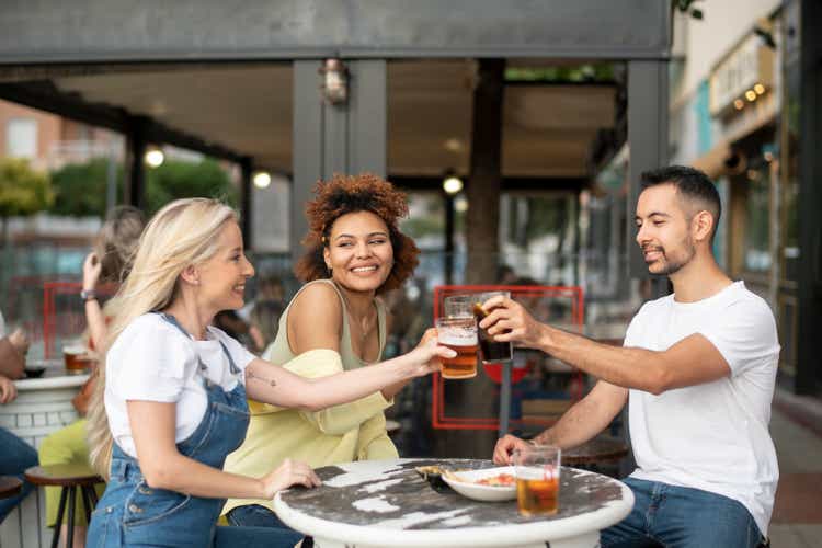 Gruppe von Freunden, die sich auf der Barterrasse im Freien amüsieren