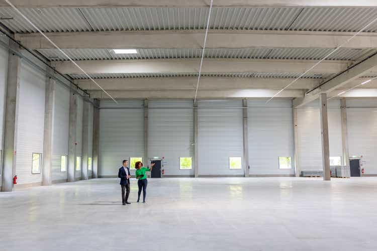 Woman with businessman in a new and large empty industrial building