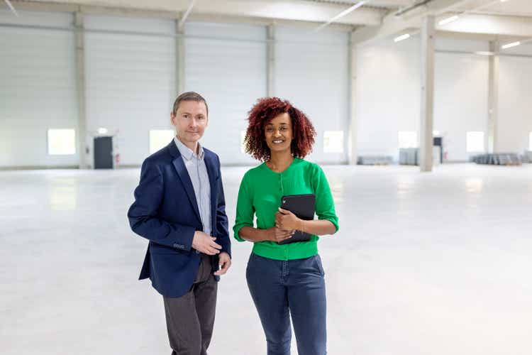 Real estate agent with businessman at new industrial building