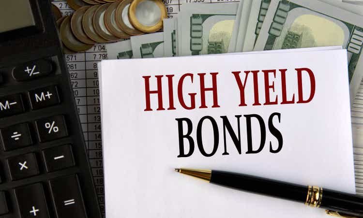 HIGH YIELD BONDS - words on a white sheet on the background of a calculator, coins and dollar bills