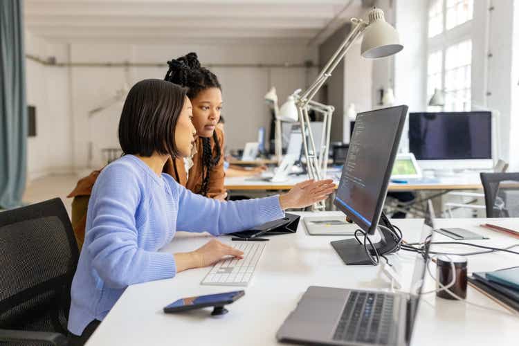 Two software developers working together on an application coding at a coworking office