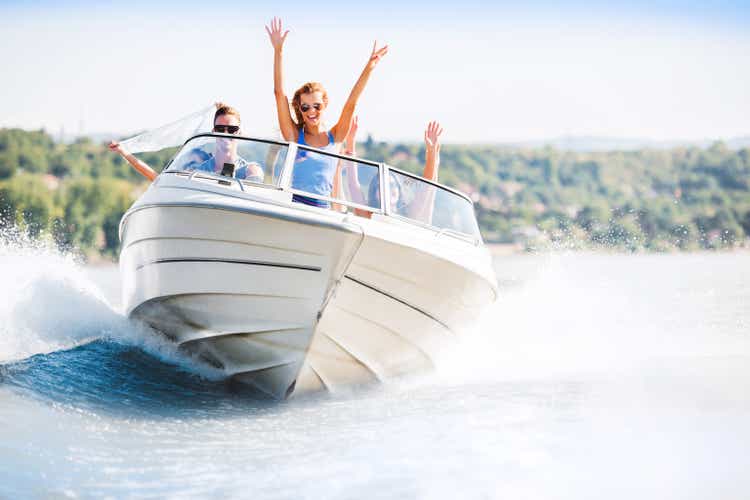 Cheerful young people riding in a speedboat