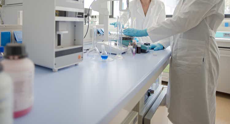 Researcher with glass laboratory chemical test tubes with liquid for analytical.