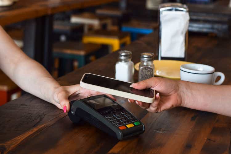 Person paying with mobile phone at a restaurant or diner