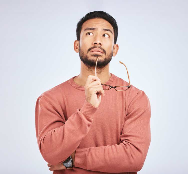 Decision making, thinking and Asian man wearing glasses, asking questions and brainstorming in studio on gray background.Why, thoughts and men have emoticons, body language or choice gestures, confusion or solutions