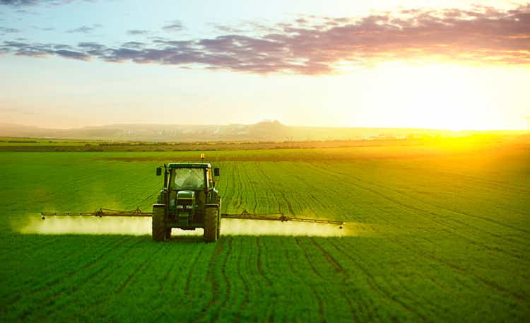 Tractor working in field of wheat