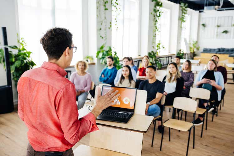 Seminar Host Giving Short Presentation To Small Audience