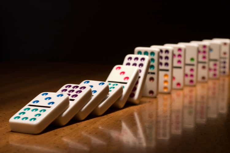 A lined up set of dominoes falling on top of one another