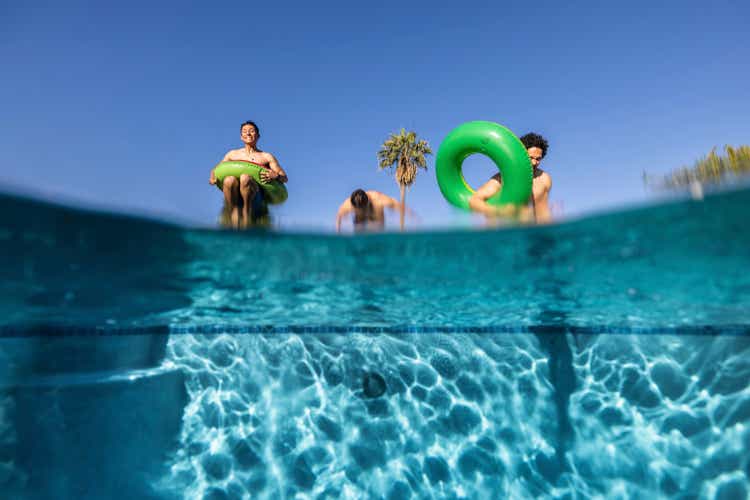 Low angle view of male friends jumping in pool