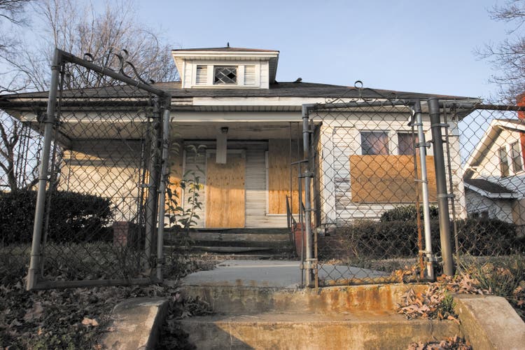 Boarded up small derelict house