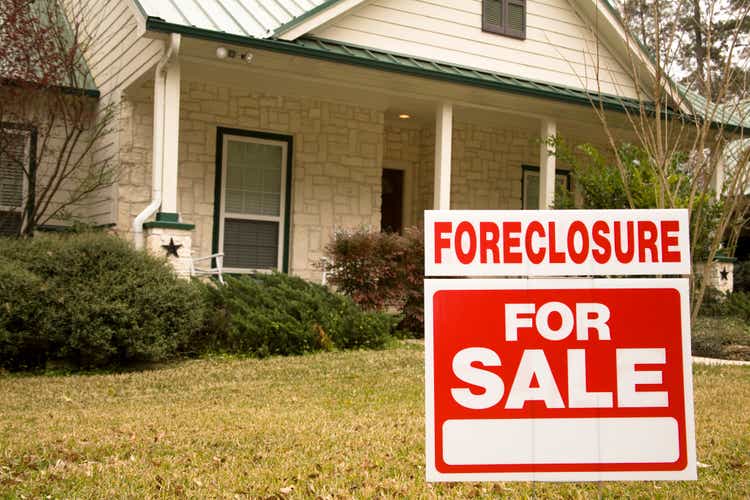Foreclosure for sale sign in front of house