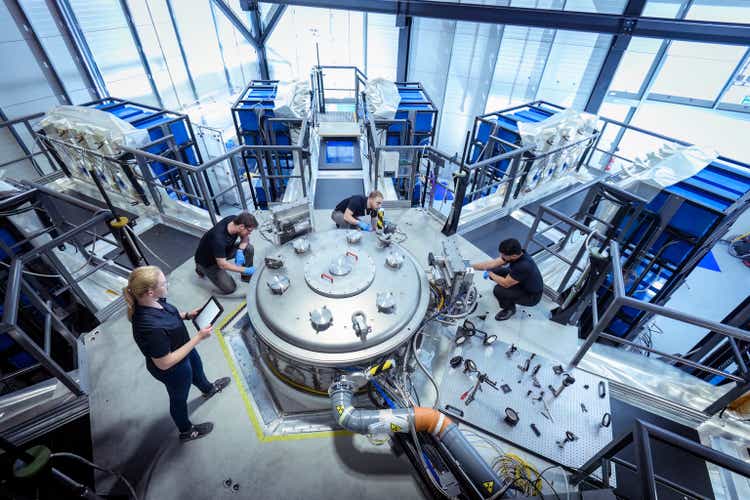 Scientists checking large pulsed power machine which creates nuclear fusion in nuclear fusion research facility