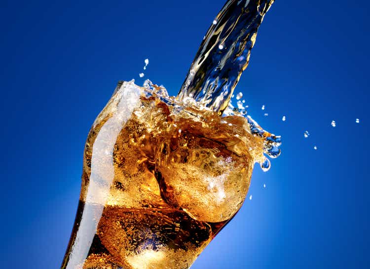 Cola with a large splash, isolated on blue