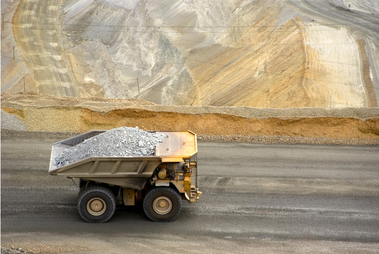 Yellow large dump truck in Utah copper mine seen from above