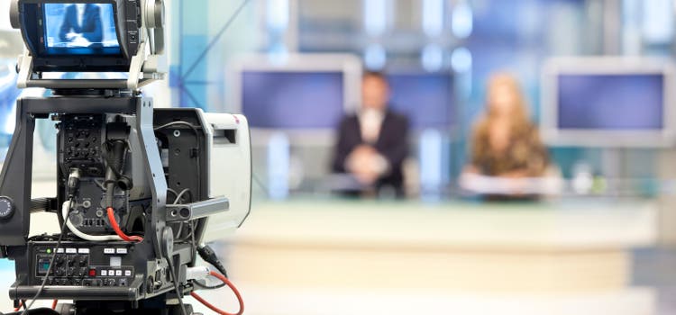 Two newsreader in front of television camera