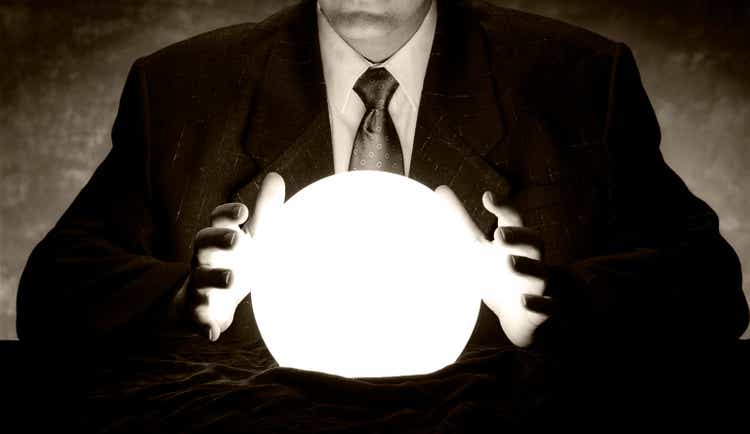 Man in suit holds hands over glowing crystal ball