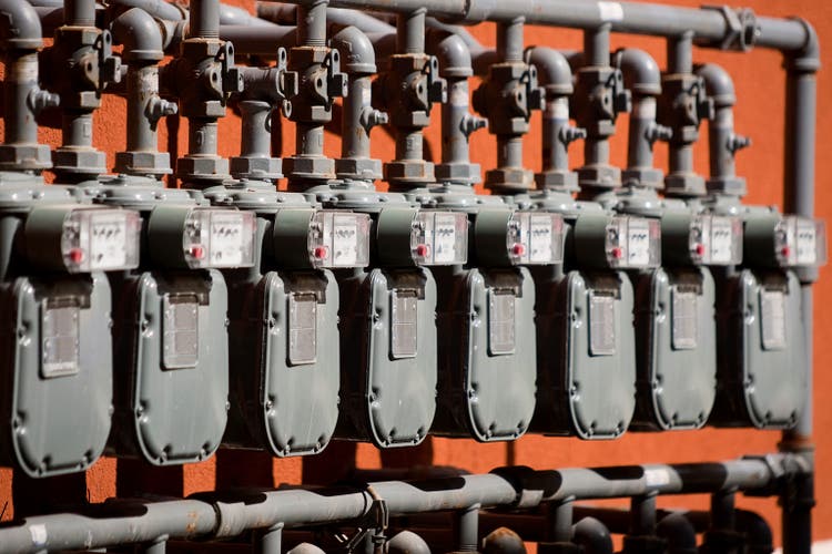 Several Natural Gas Meters in a Row on Orange Wall