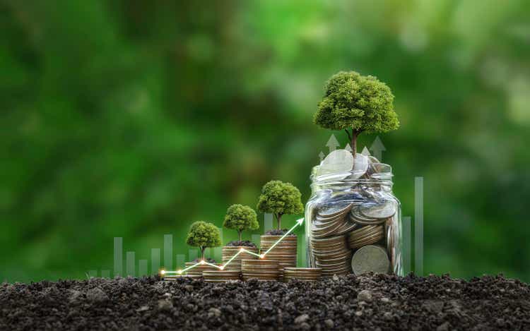 The tree grows on stacked coins on the soil. Renewable energy generation is essential for the future. Saving money for the future. Investment Ideas and green business growth.