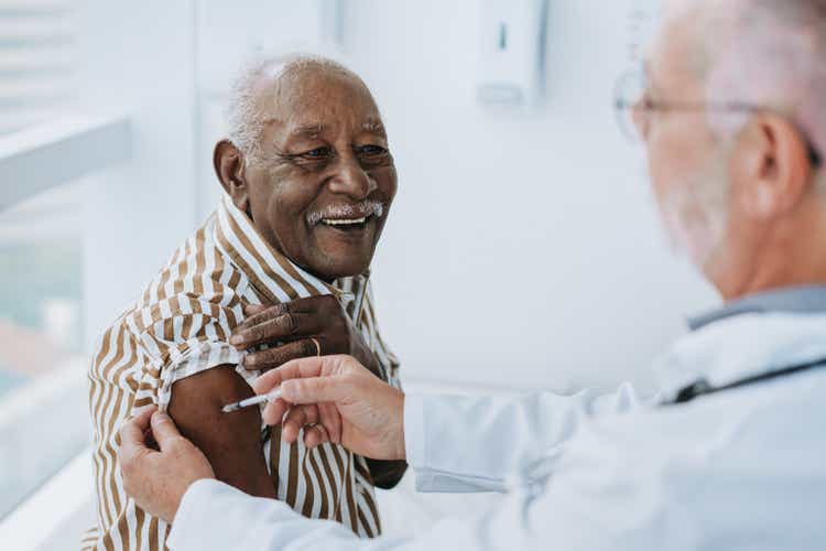 Doctor giving vaccine to patient