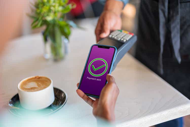 Customer paying for her coffee via a banking app