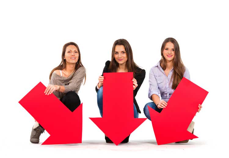 Three beautiful women holding arrows pointing down