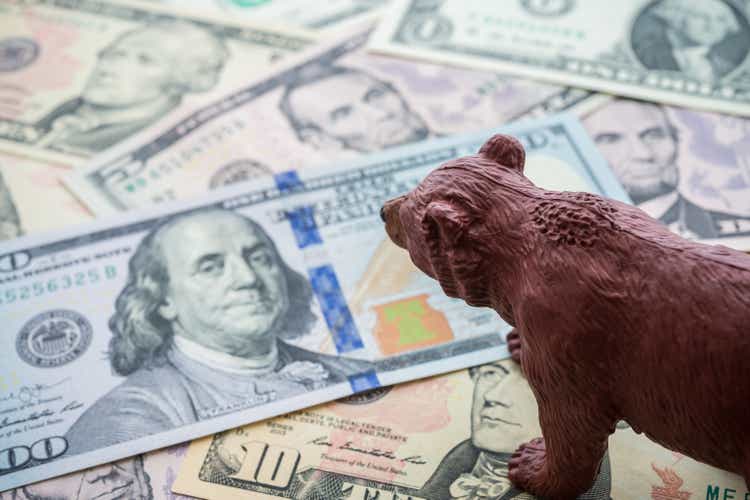 Walking bear on US dollar banknotes money cash background.