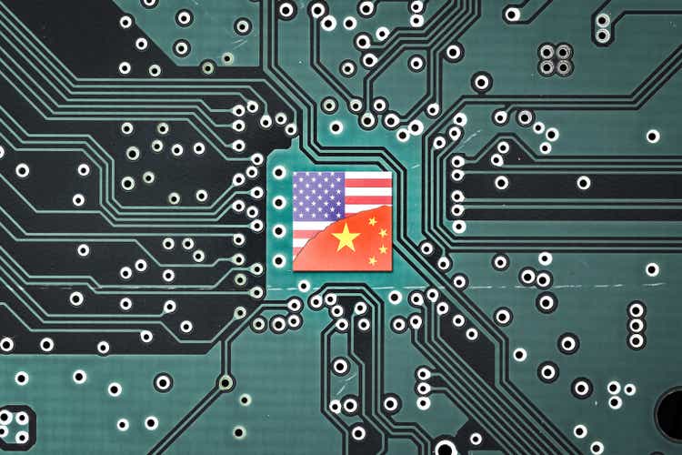 Technology war between China and the United States.  American and Chinese flags on microprocessor